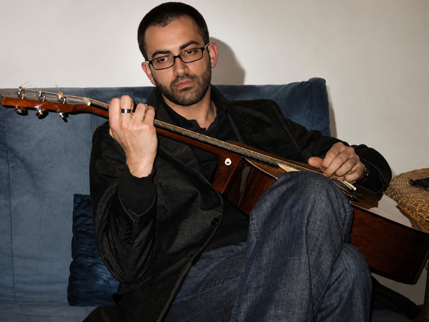 Fingerpicking an acoustic guitar, seated