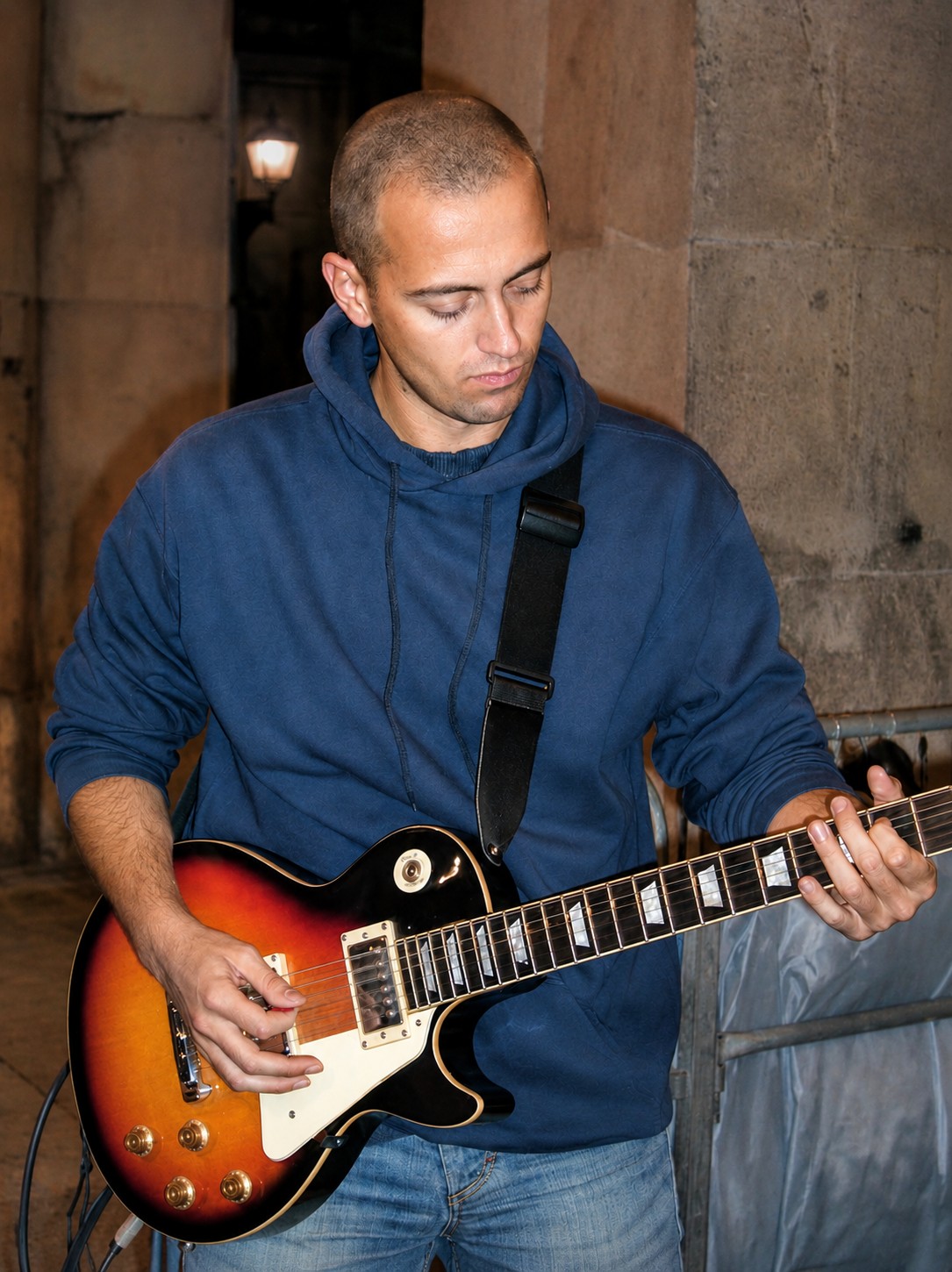 Playing a sunburst Les Paul outdoors, under an old stone archway