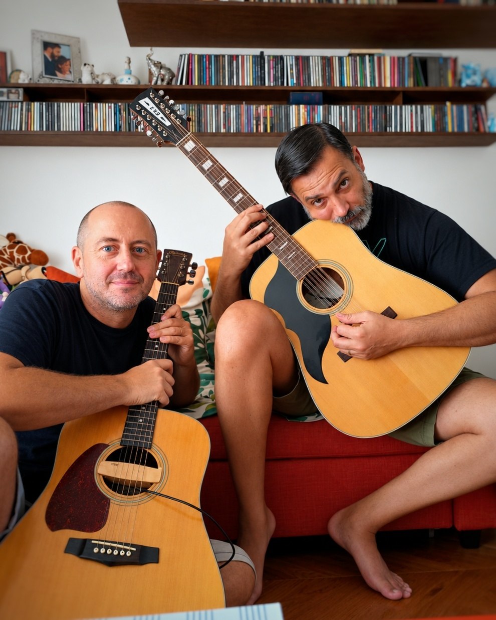 FX and Fenni sitting together, each holding an acoustic guitar