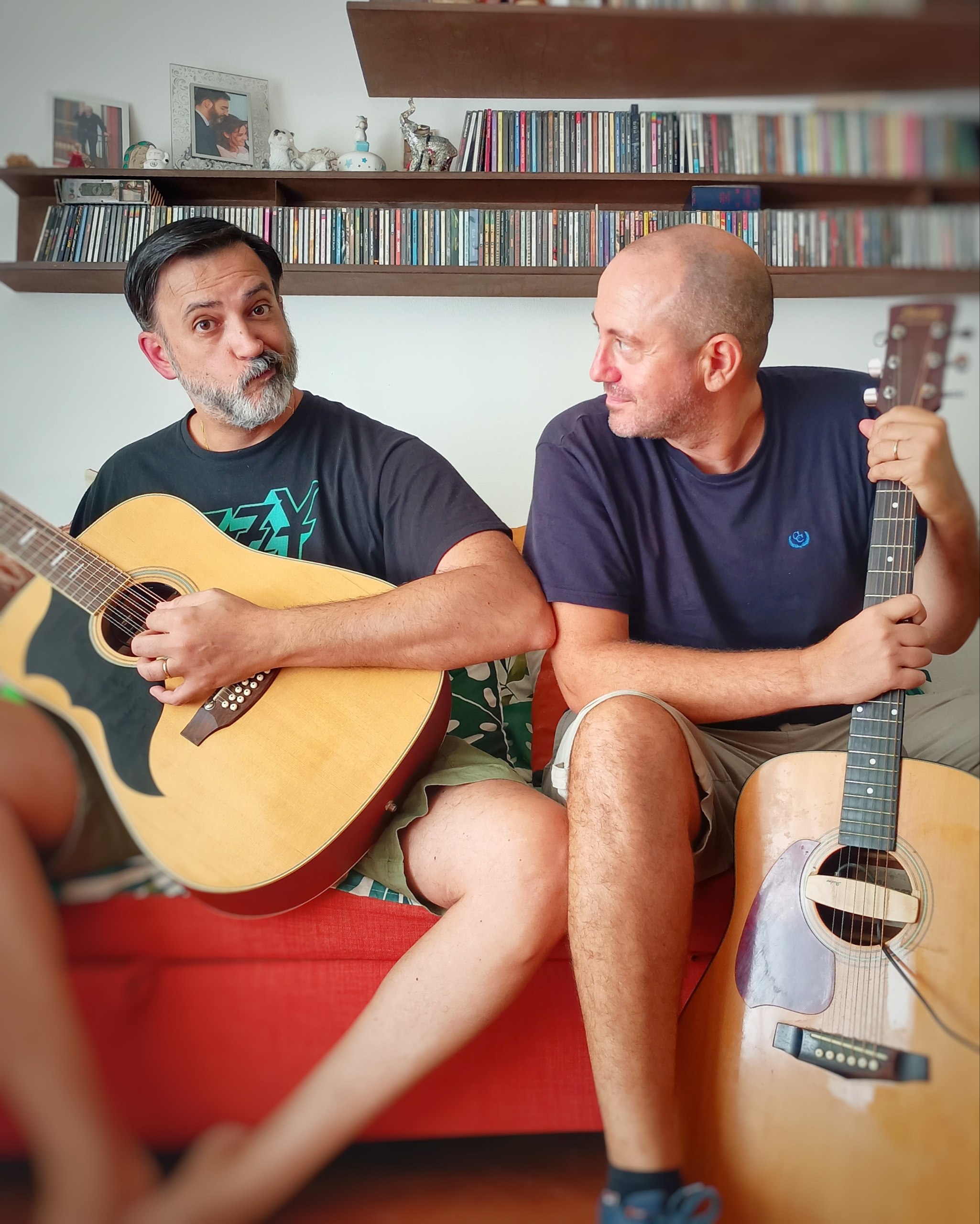 FX and Fenni sitting side by side with their guitars, mid-conversation